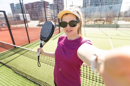 Portrait of attractive woman padel tennis player in outdoor court.の写真素材