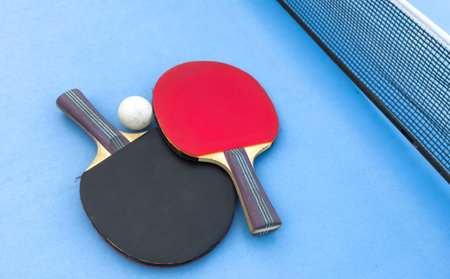 table tennis or ping pong racket and balls on a blue tableの写真素材