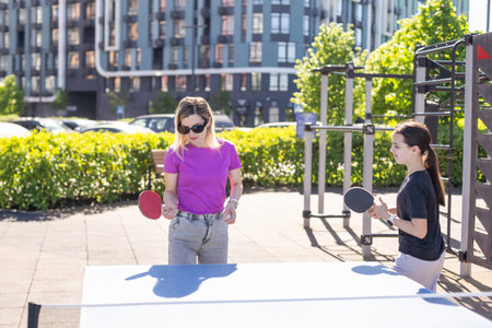 Adult woman instructor teaching girl play table tennisの写真素材