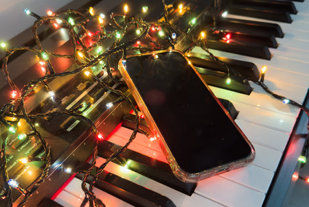 Chritmas balls and gift boxes on classical piano keyboard, smartphoneの写真素材