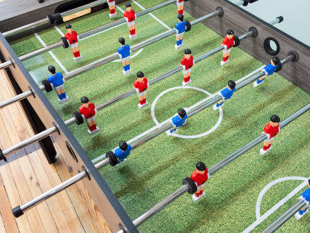 Classic Foosball Table Game With Players in Red and Blue Jerseys During Daytime Indoor Match....