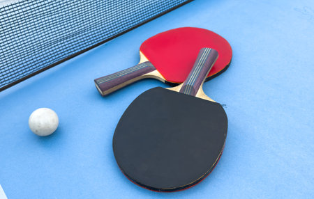 ping pong paddles on blue table, ping pong concept, active sportsの写真素材