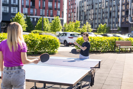 Happy mother and daughter play ping pongの写真素材