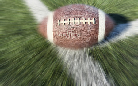 On a grass field there is a football ball with motion blur effect