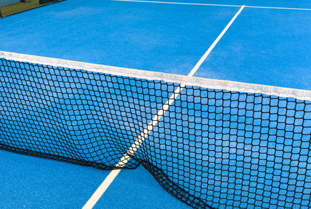 balls near the net of a blue paddle tennis court, sports courtsの写真素材