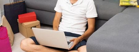 Young man buying music on internet with laptopの写真素材