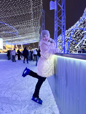 Happy smile woman in winter with skates on outdoors ice rinkの写真素材