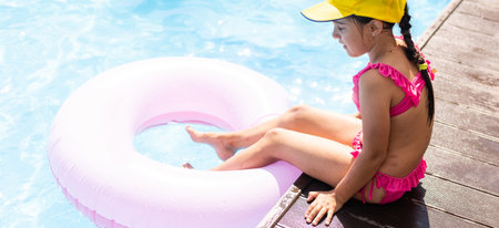 Funny little girl swims in a pool in an life preserverの写真素材