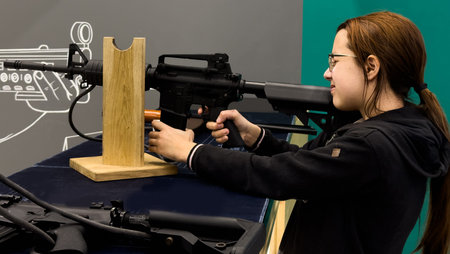 Girl is training shooting with a rifle