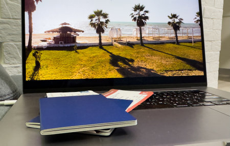 a passport on laptop computer keyboard. Online travel booking and visa application.の写真素材