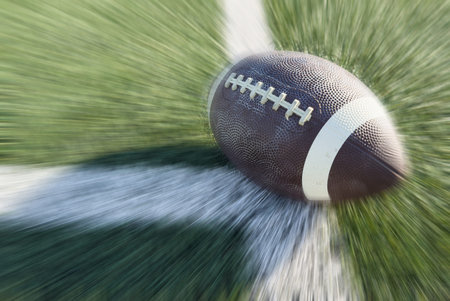 On a grass field there is an american football ball