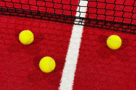 paddle tennis balls near the lines of a red paddle tennis court, racket sports conceptの写真素材