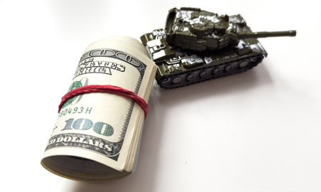 Military tank, American dollar bills. Concept: military and financial assistance to Ukraine, high arms costs, arms supplies from America.の写真素材