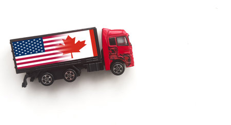 Miniature toy at table with white background. There is american flag on toy of truck.の写真素材
