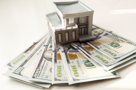 House standing on a pile of dollar bills. Investment, real estate and property conceptの写真素材