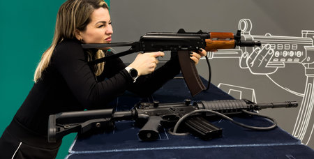 Woman aiming pistol at target out indoor firing range or shooting range.