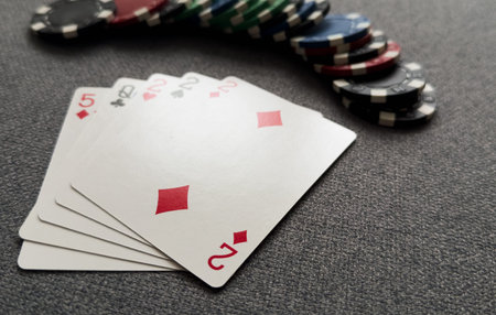 Chips are colored for poker and playing cards on the poker table.