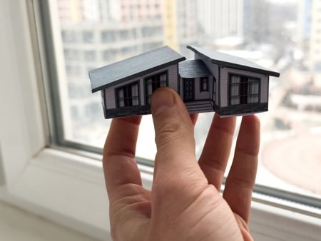 small paper toy house in hand on backgroundの写真素材