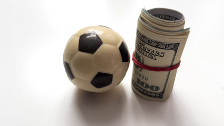 Little soccer ball with a roll of dollars