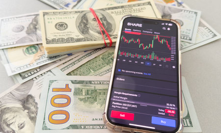 Trade. Analysis of exchange information. Profit from exchange operations. Bidding on the Internet. A person studies the chart of changes in quotes on a smartphone. Stock analysis. Exchange strategies.の写真素材