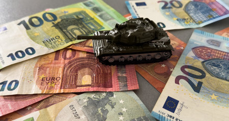 Tank on background of banknotes. Currency war. War costs, military spending. Making money from war. Money laundering on War. Military economy. Military tank and European banknotes. Weapons trade.の写真素材