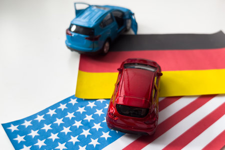 Mini toy car and flags of the USA and Germanyの写真素材