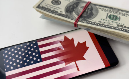 Tariffs between the United States and Canada. USA and Canadian flags, and wooden cubes with word tariffs.の写真素材