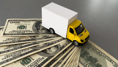 White toy truck lie on dollars, space for text.の写真素材