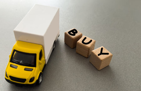 Big cardboard box package on a grey truck ready to be delivered on yellow background