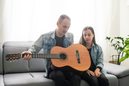 Artistic talented girl showing her latin music teacher the new song she learned to play on the...