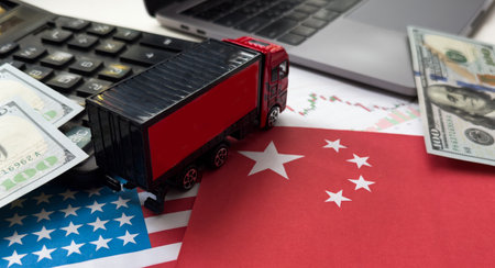 Chip shortage and US-China trade conflict. Global chip shortage crisis and China-United States trade war concept. China flag and US flag on china map and hand holding computer chip on background.の写真素材