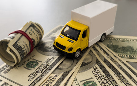 Toy car truck with money isolated on white backgroundの写真素材