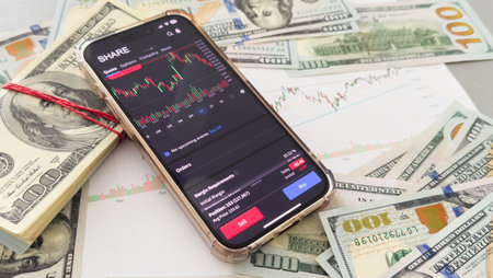 Trade. Analysis of exchange information. Profit from exchange operations. Bidding on the Internet. A person studies the chart of changes in quotes on a smartphone. Stock analysis. Exchange strategies.の写真素材