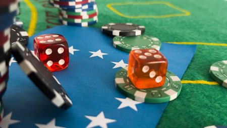 Dice, playing cards, and poker chips on a gaming table.の写真素材