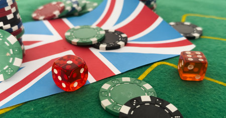 Dice with poker chips and playing card on background of dollar bills. flag of Great Britainの写真素材