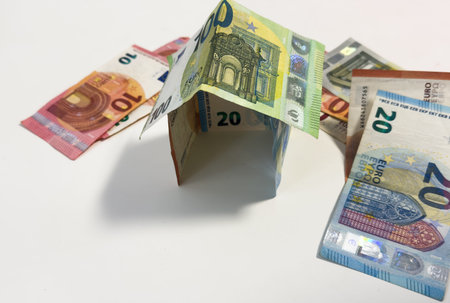 House made of euro banknotes on white background - Concept of building bonus, real estate investment, mortgage and home insuranceの写真素材