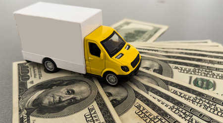Toy car truck with money isolated on white backgroundの写真素材