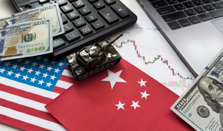 Chip shortage and US-China trade conflict. Global chip shortage crisis and China-United States trade war concept. China flag and US flag on china map and hand holding computer chip on background.の写真素材