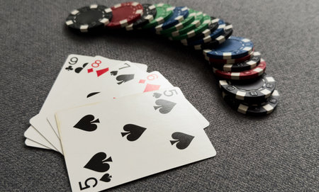 A popular and exciting poker game with a winning combination. Playing cards and chips on a table in a poker club. Advertising space.の写真素材