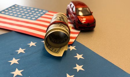 100 dollars on a US and EU flags background. US and European Union trade, customs, toy car modelの写真素材
