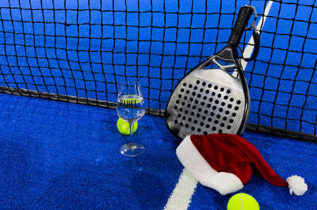 Christmas and New Year concept with Santa hat, padel tennis ball. Winter sport healthy layout. Holidays conception. Place for your text.の写真素材