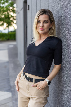 Young blonde woman smiling confident looking to the side at streetの写真素材