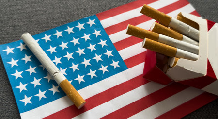 a cigarette on the background of the American flag. Concept of nicotine addiction problems in the US.の写真素材