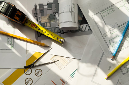 Architects house model with measurement tool and blueprints on architect desk. A architects home model with plan and blueprints. Business, architecture, building and construction concept.の写真素材