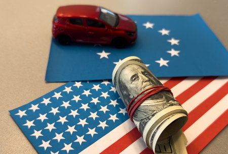 100 dollars on a US and EU flags background. US and European Union trade, customs, toy car modelの写真素材