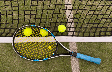 tennis racket with a tennis ball on a tennis courtの写真素材