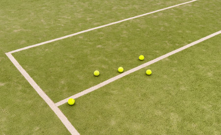 yellow tennis balls in court on green artificial grass, indoor sports concept and sporty lifestyleの写真素材