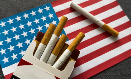 a cigarette on the background of the American flag. Concept of nicotine addiction problems in the US.の写真素材