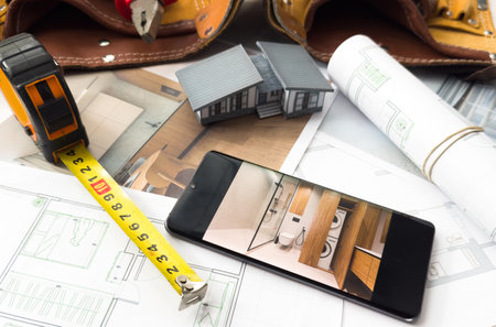 Architectural model on desk with smartphone, drawing technical tools and blueprints. Architecture, building, construction and real estate business.の写真素材