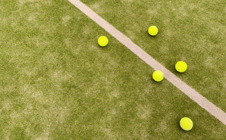yellow tennis balls in court on green artificial grass, indoor sports concept and sporty lifestyleの写真素材